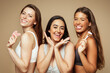 © Prostock-studio - Glad millennial diverse women in underwear enjoy beauty care, use stone, roller from quartz