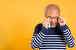 © sorapop - Asian elder man crying raise glasses with tissue wipe red eyes studio shot isolated on yellow background, Portrait senior old man sad wiping away his tears, Upset depressed lonely