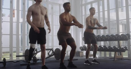 Wall Mural - Three shirtless multiracial young men in sportswear doing squats at the gym