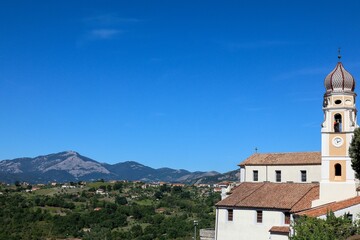 Wall Mural - Aerial shot of lush scenery and the Church of Saint James against the blue sky in Lauria, Italy