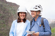© luciano - Senior women hikers with protective helmets standing on the top of mountain in a trekking day - Smiling female tourists enjoying holidays and healthy lifestyle - Freedom sport concept
