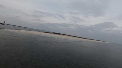 Wall Mural - Aerial of the calm sea waves and the sandy shore under the gloomy sky