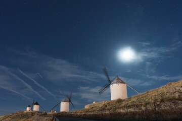 Canvas Print - Spectacular night photography with windmills illuminated under the moonlight. Consuegra.