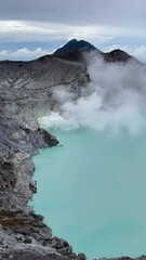 Wall Mural - Acid lake with sulfur steam near Mount Ijen, Java, Indonesia, vertical footage