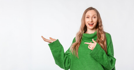 Wall Mural - Enthusiastic young blonde woman, pointing finger at promo banner, showing copy space to the left, standing over white background