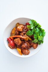 Wall Mural - Stewed chicken fillet pieces with vegetables in white bowl with cilantro.