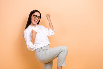 Poster - Photo of lucky excited woman dressed white shirt eyewear shouting yes rising fists empty space isolated beige color background