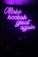 Poster - Vibrant purple neon sign with the words 'Make hookah great again' illuminated in a darkened room