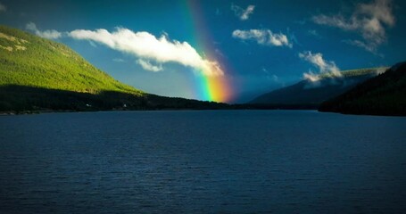 Wall Mural - landscape scene of double rainbow over kootenay lake in canada with cloudy sky