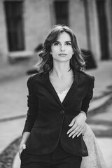 Portrait of a successful business woman in front of modern business building. Young manager poses outside. Woman employee of an office.