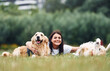 Lying down on the ground. Woman with beautiful dogs are in the field outdoors