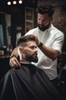 © GoodandEvil - Barber serving a stylish bearded client in a retro barbershop
