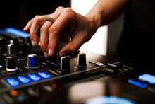 Close Up Portrait Of Female Disc Jockey Hand Mixing Tracks On Professional Sound Mixer, Playing Music During Night At Nightclub. Nightlife Concept.