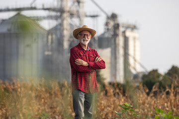 Poster - Farmer in front of grain silos in corn field