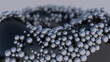 Metallic balls on black surface. Abstract illustration, 3d render, close-up.