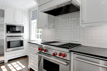 Wall Mural - Luxury White Modern Kitchen Interior with White Cabinets with Gas Stove and Black Stone Counters