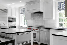 Luxury White Modern Kitchen Interior With White Cabinets With Gas Stove And Black Stone Counters