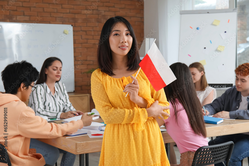 Young Asian woman with Polish flag at language school