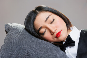 Tired sleepy woman receptionist with closed eyes lying head down on pillow. Restaurant catering service young attractive exhausted asian waitress sleeping and relaxing closeup