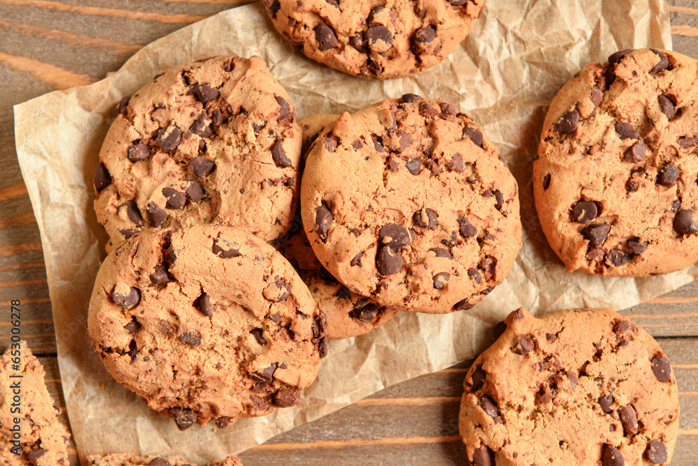 Tasty cookies with chocolate chips on wooden background