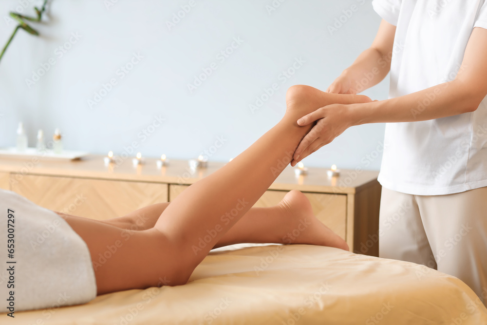 Beautiful woman receiving leg massage in spa salon