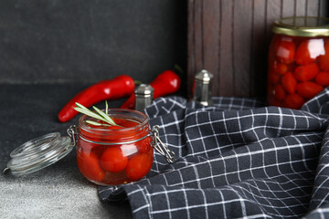 Wall Mural - Jar of pickled tomatoes with rosemary and chili pepper on grunge background