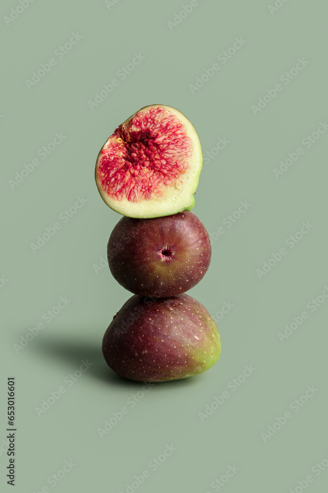 Fresh ripe figs on green background