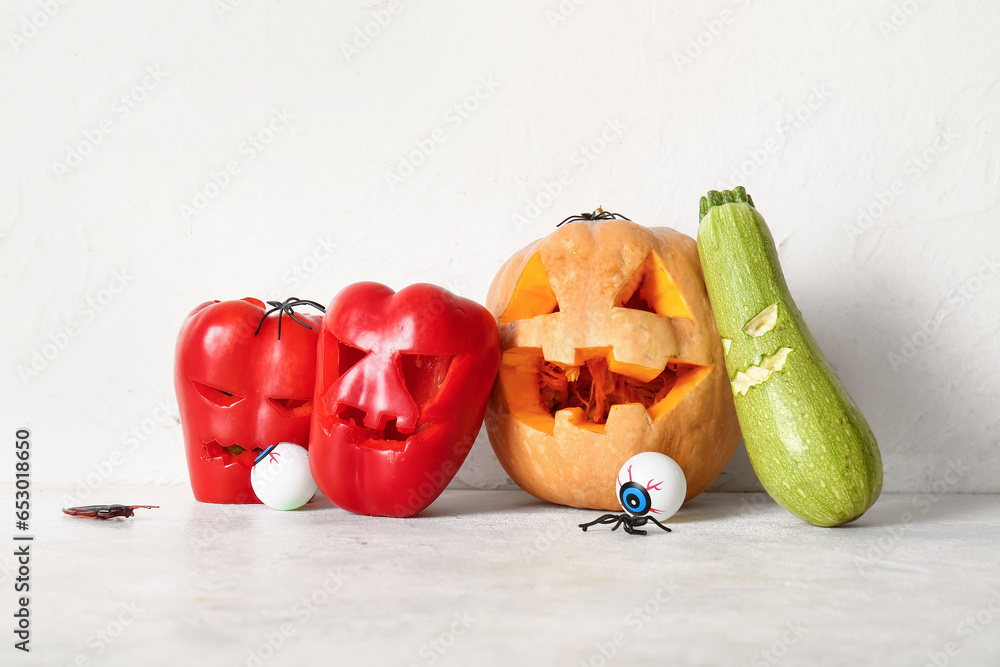 Carved vegetables for Halloween with spiders and eyes on white background