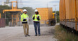 © naraichal - A couple of Commercial dock workers walking and discussing the logistics schedule
