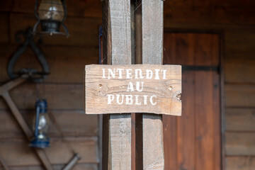 interdit au public french sign text on wooden board means forbidden to the public front wood house no access limit