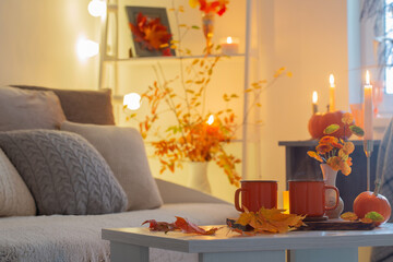 two orange cups with hot drink in autumnal interior