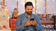 © Knot9 Images - Indian man using a mobile phone - browsing smartphone. Diwali festival celebration. A well-dressed young man on Diwali sitting against the colorful decorated background - Hindu festival  an Indian ...