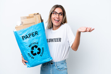 Wall Mural - Young pretty Uruguayan woman holding a recycling bag full of paper to recycle isolated on white chroma background with shocked facial expression