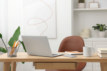 Home office. Stylish workplace with laptop and stationery on wooden desk indoors