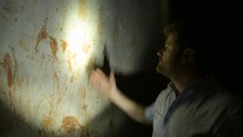 Man Touching Prison Wall Bloody Handprints Illuminated By Torchlight In Uganda, Africa. Violence Concept
