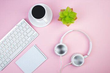 pink office table with computer, pen and a cup of coffee, lot of things. Top view with copy space.