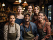 © fizkes - Group of multiethnic workmates, cafeteria or restaurant workers, smile look at camera pose indoor, enjoy friendship at work and unity, pose with African man, small business owner. Store staff portrait