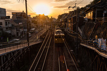 View From A Railway Bridge With A Yellow Japanese Train Approaching During Sunset, Onomichi, Honshu, Japan