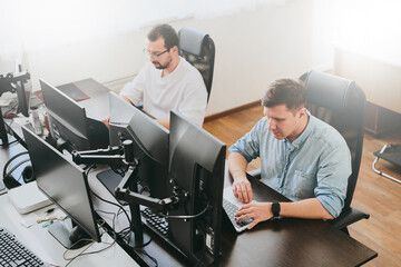 portrait of two professional male programmers working on computer in diverse offices. modern it tech