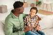 © Prostock-studio - Cheerful African American Dad Talking To Little Son Embracing Indoors