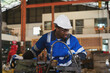 © amorn - Male engineer worker working with lathe machine in industry factory, wearing safety uniform, helmet. Male technician worker maintenance parts of machine in workshop plant