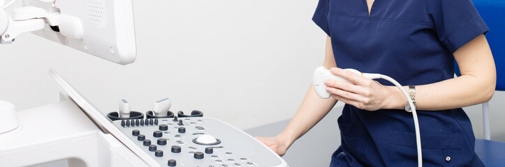 Wall Mural - Female doctor sitting in office in a hospital doing ultrasound scanning diagnostic