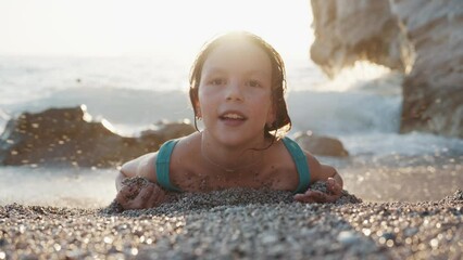 a child girl in a swimsuit playing and having fun in the oncoming wavess