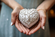 Female Hands Showing White Beaded Heart With Delicacy