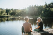 © Johnér - Two senior women sitting on rock at lakeshore