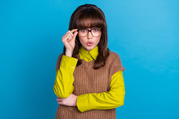 Poster - Portrait of speechless girl with retro hairdo wear knit vest touching glasses astonished staring isolated on blue color background