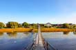 Suspension bridge to the village of Shikhirikha across the picturesque Malkurya river in the Primorsky district of the Arkhangelsk region on a sunny summer day. Russia