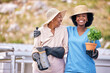 Old woman, gardening and portrait with nurse outdoor with plant, flowers and happiness in backyard nature. Happy, senior and african caretaker with wellness or agriculture greenery in retirement