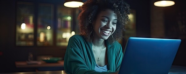 black woman with afro hair and smiling in front of the laptop, business concept