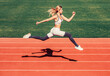 © Yevhen - Woman running jump on stadium track. Sportswoman in sportswear jumping. Woman running during. Sport backgrounds. Runner